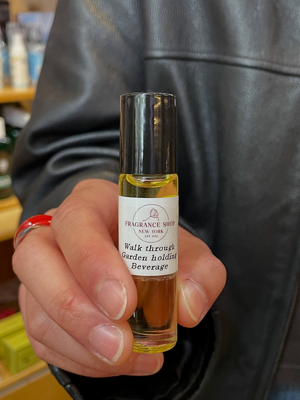 A finished custom roll-on perfume, labeled and held out ready to take home